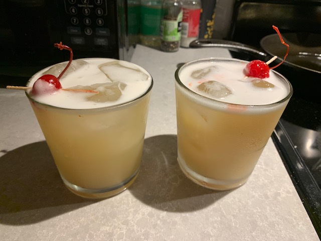 Classic Whiskey Sour frothed with egg white and a maraschino cherry